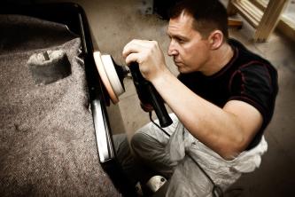 Uwe Weschenfelder beim Polieren eines Steinway-Flügels, in der Hand eine Poliermaschine