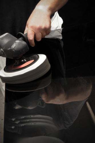 Poliermaschine mit Polierschwamm in der Hand